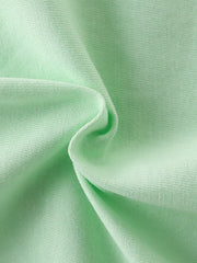 Close-up of soft light green cotton fabric texture with gentle folds