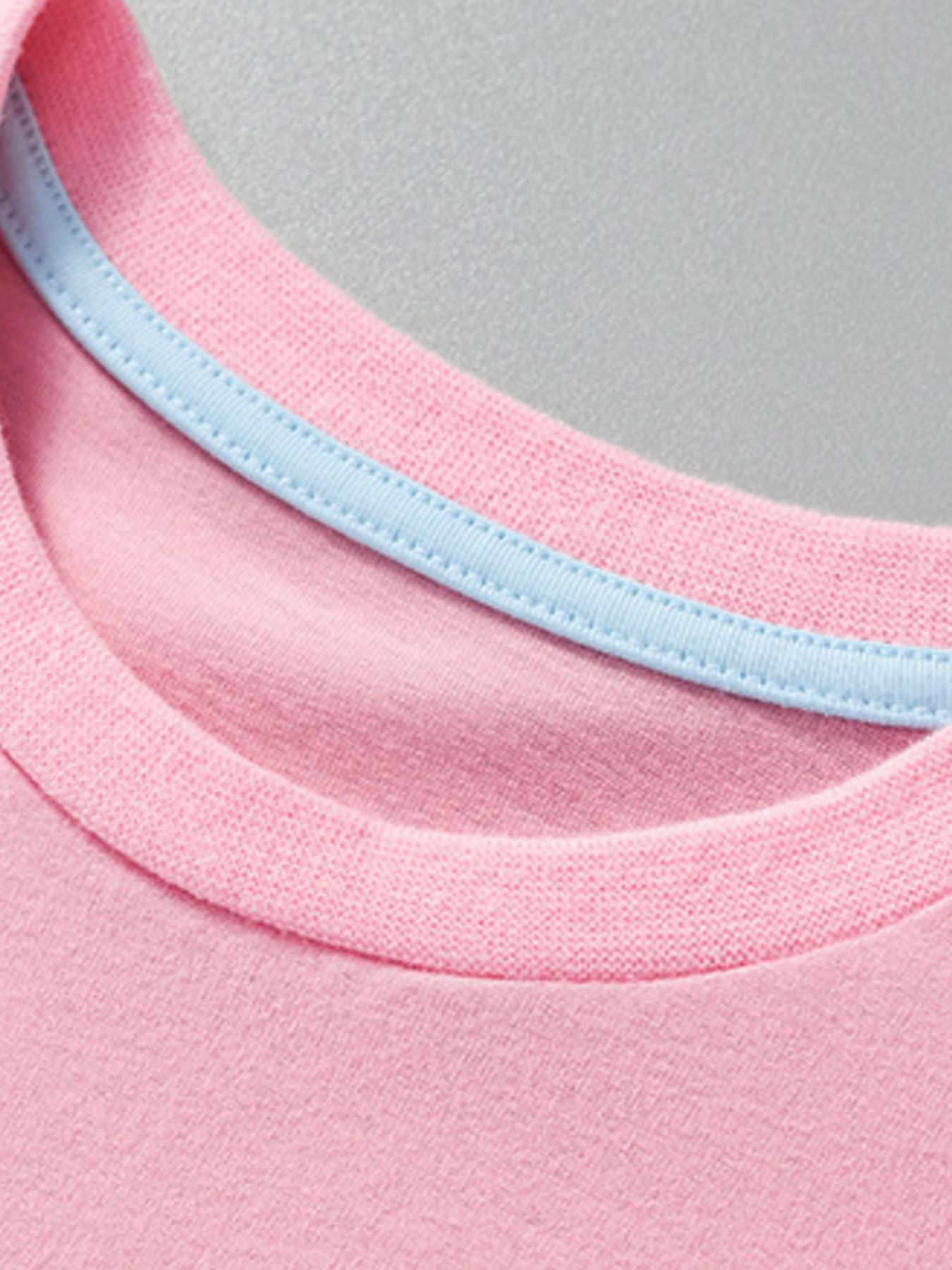 Close up of the round neckline with light blue inner trim on a pink children's unicorn tee