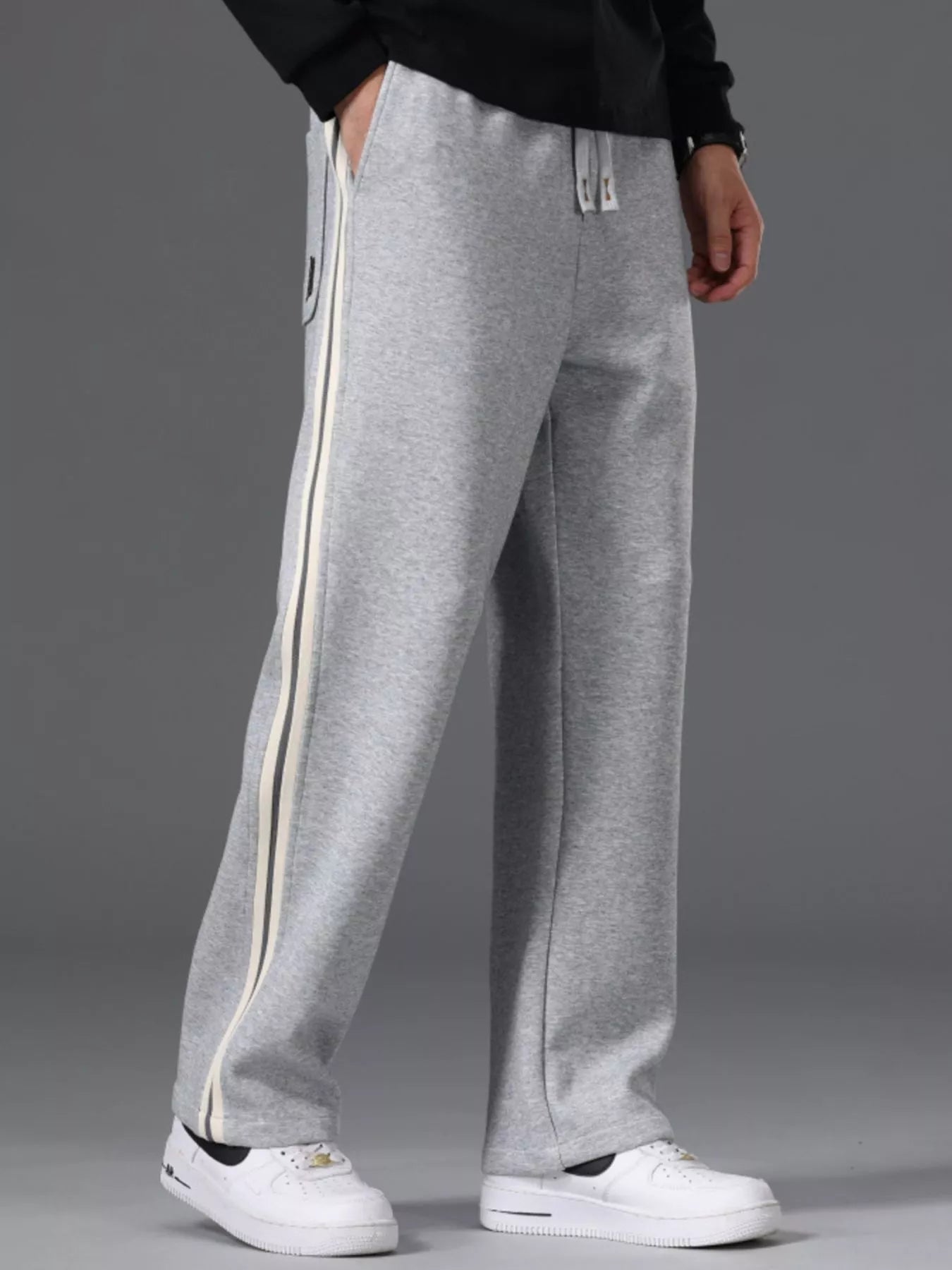 Men's side striped casual pants with a drawstring waist and pockets.