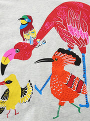 Close-up of colorful bird print including a large red bird and orange crested bird on gray fabric