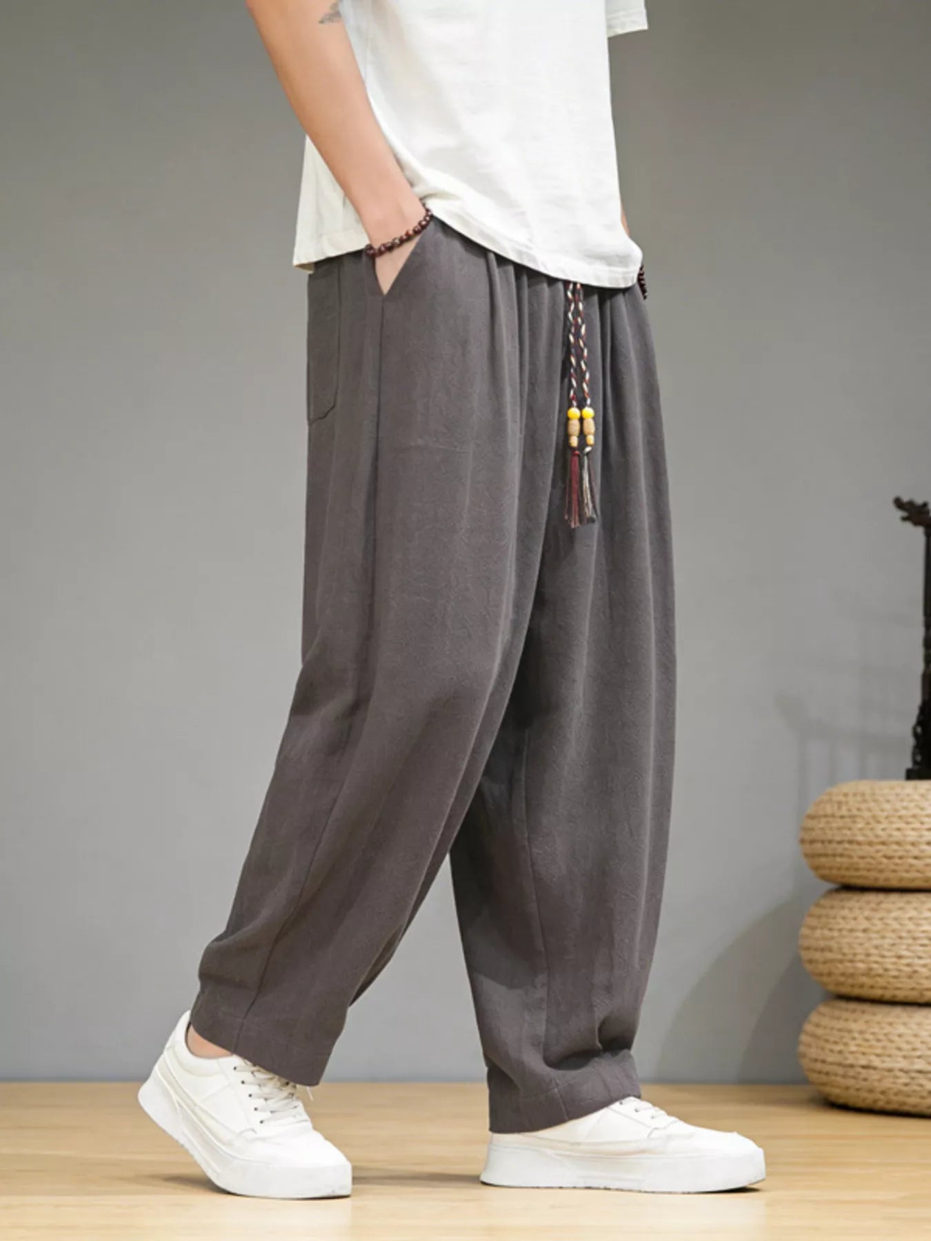 Men's loose fit casual pants with a drawstring waist and pockets.