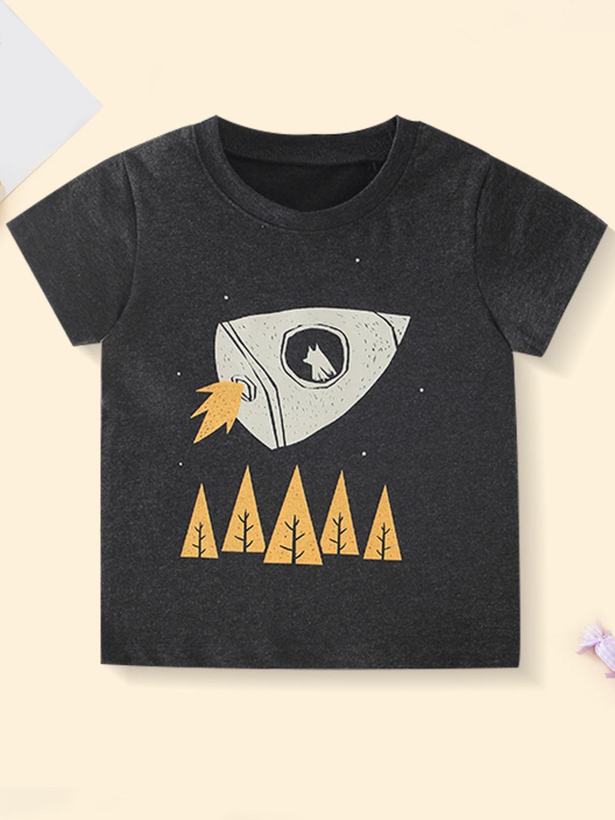 Black children's t-shirt with white rocket flying over yellow trees, front view