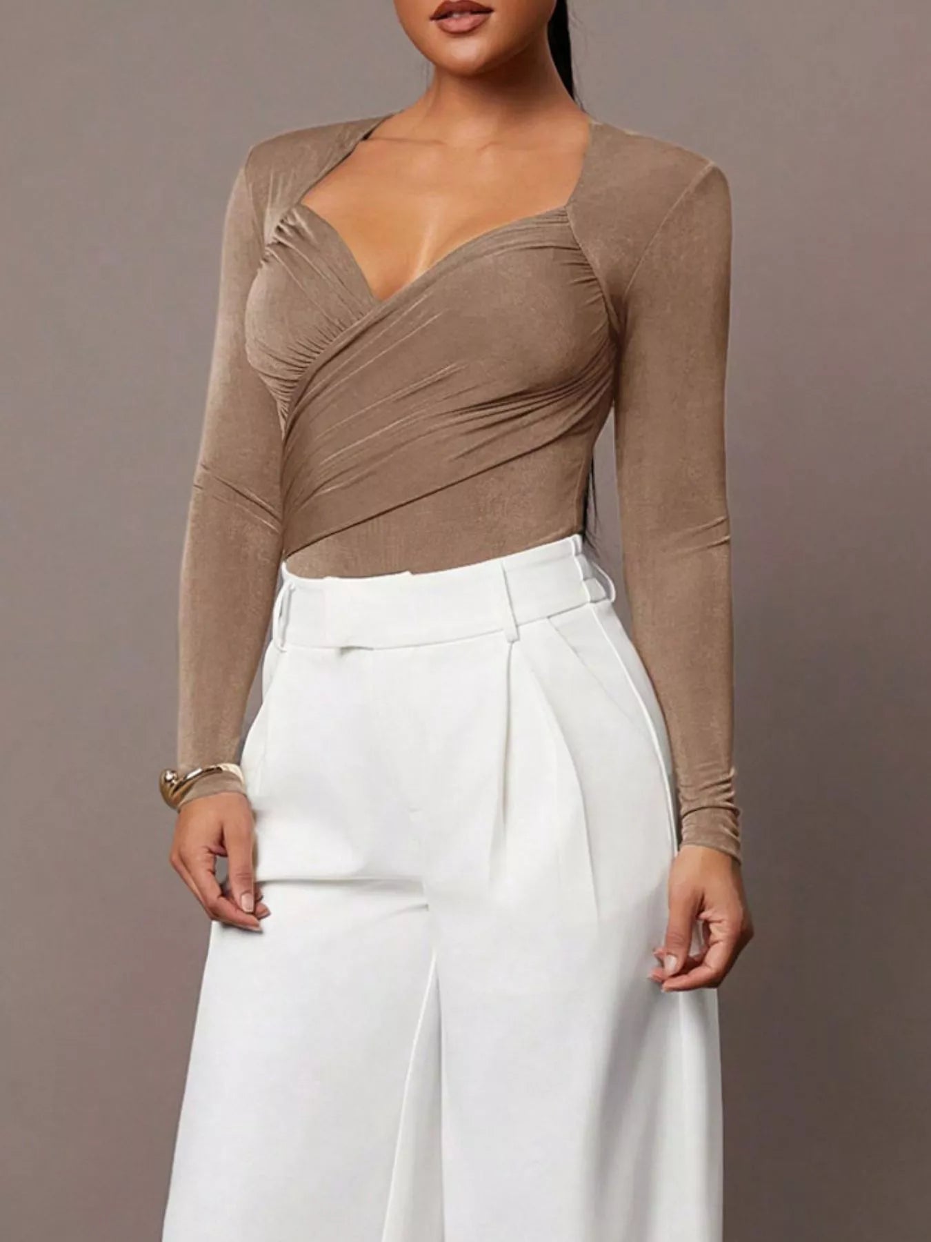Full front view of khaki ruched surplice bodysuit styled with white wide leg trousers