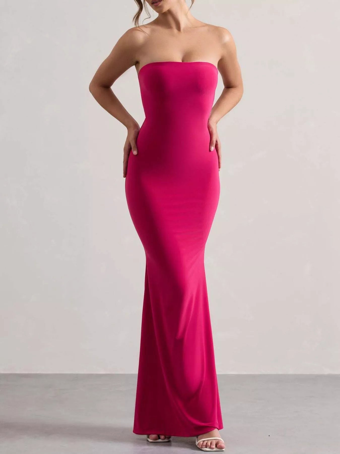 Model wearing strapless rose red tube maxi dress, front view with hands on hips