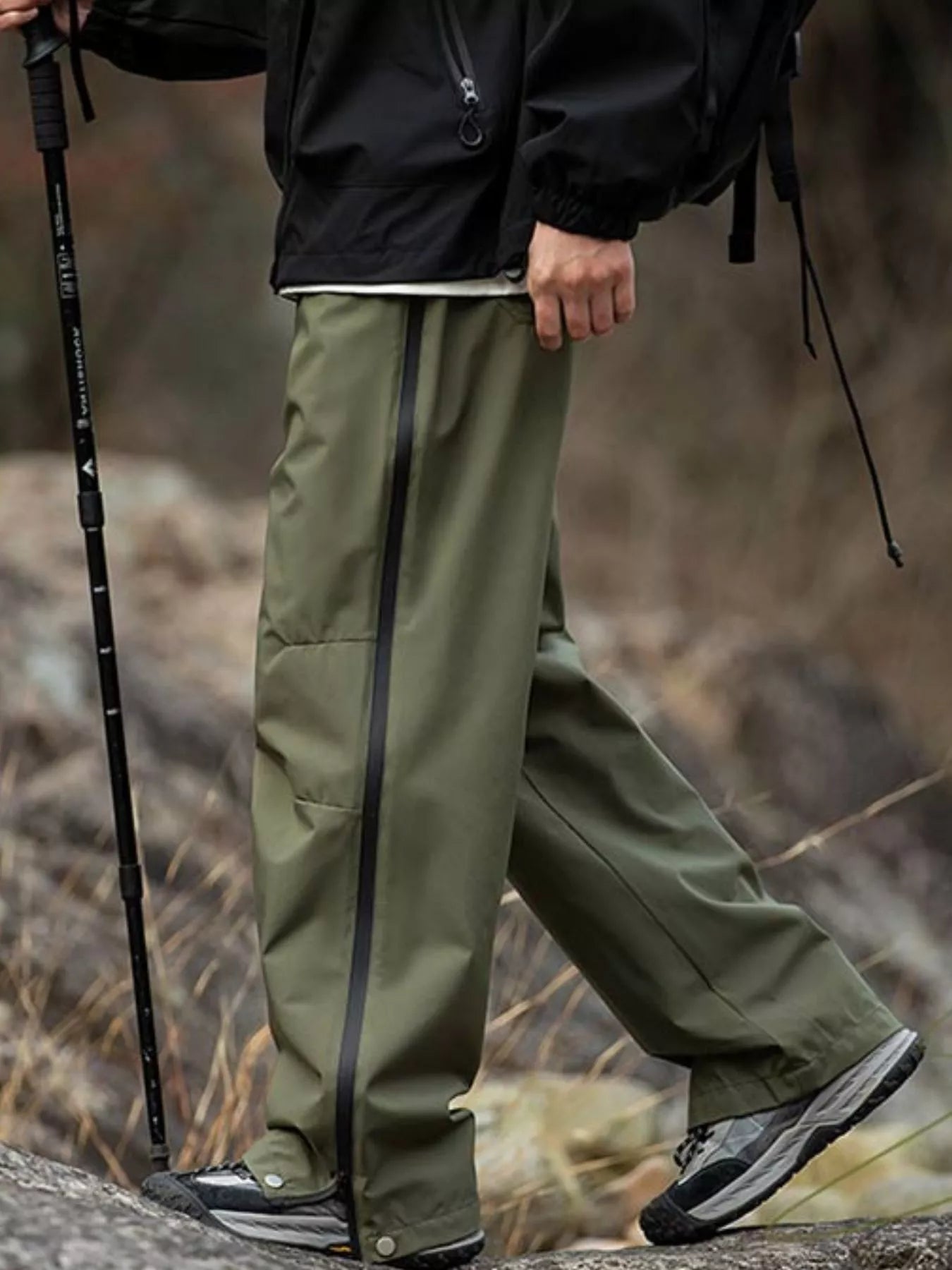 Men's olive green tactical cargo pants with multiple pockets and a drawstring waist.
