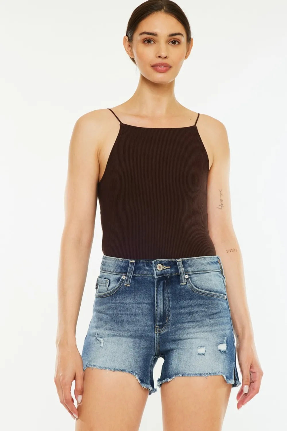 Women's high-waisted denim shorts with raw hems, washed detailing, pockets, and slit details.