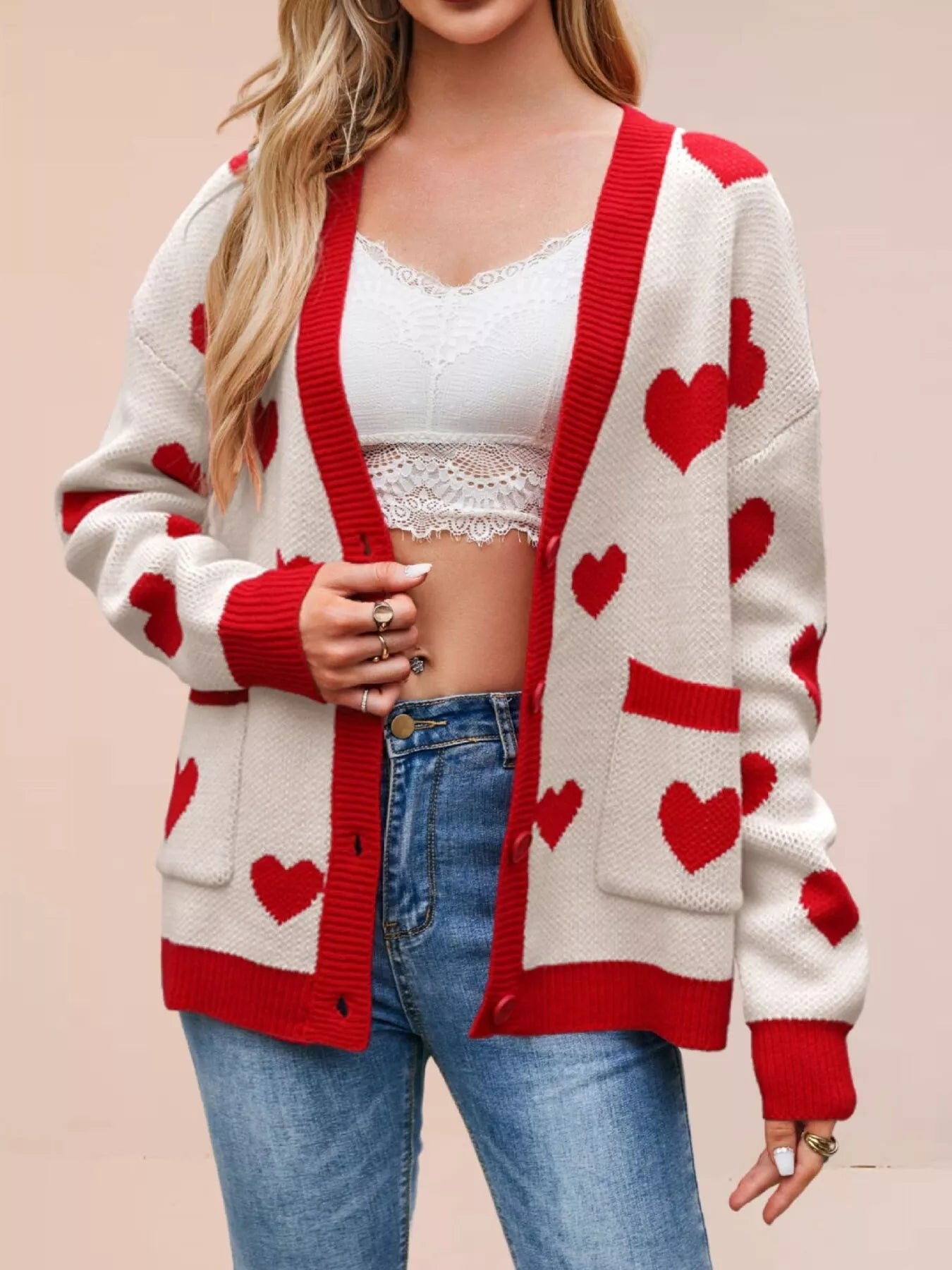 Cream knit cardigan with red hearts and red trim worn open