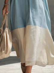 Close lower view on model of light blue color block midi dress showing cream hem panel