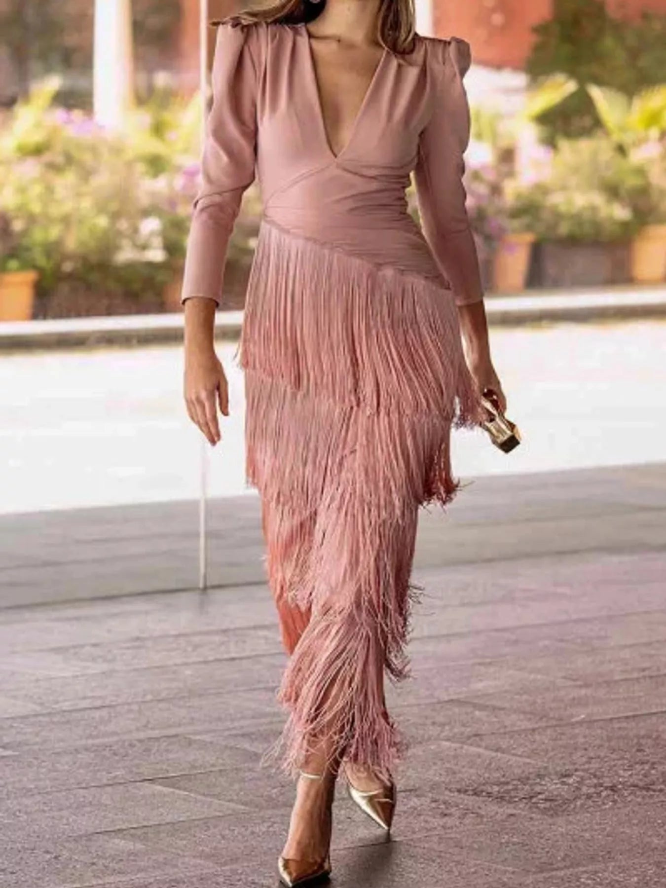Full length view of a pink fringed maxi dress with a tiered fringe skirt worn walking