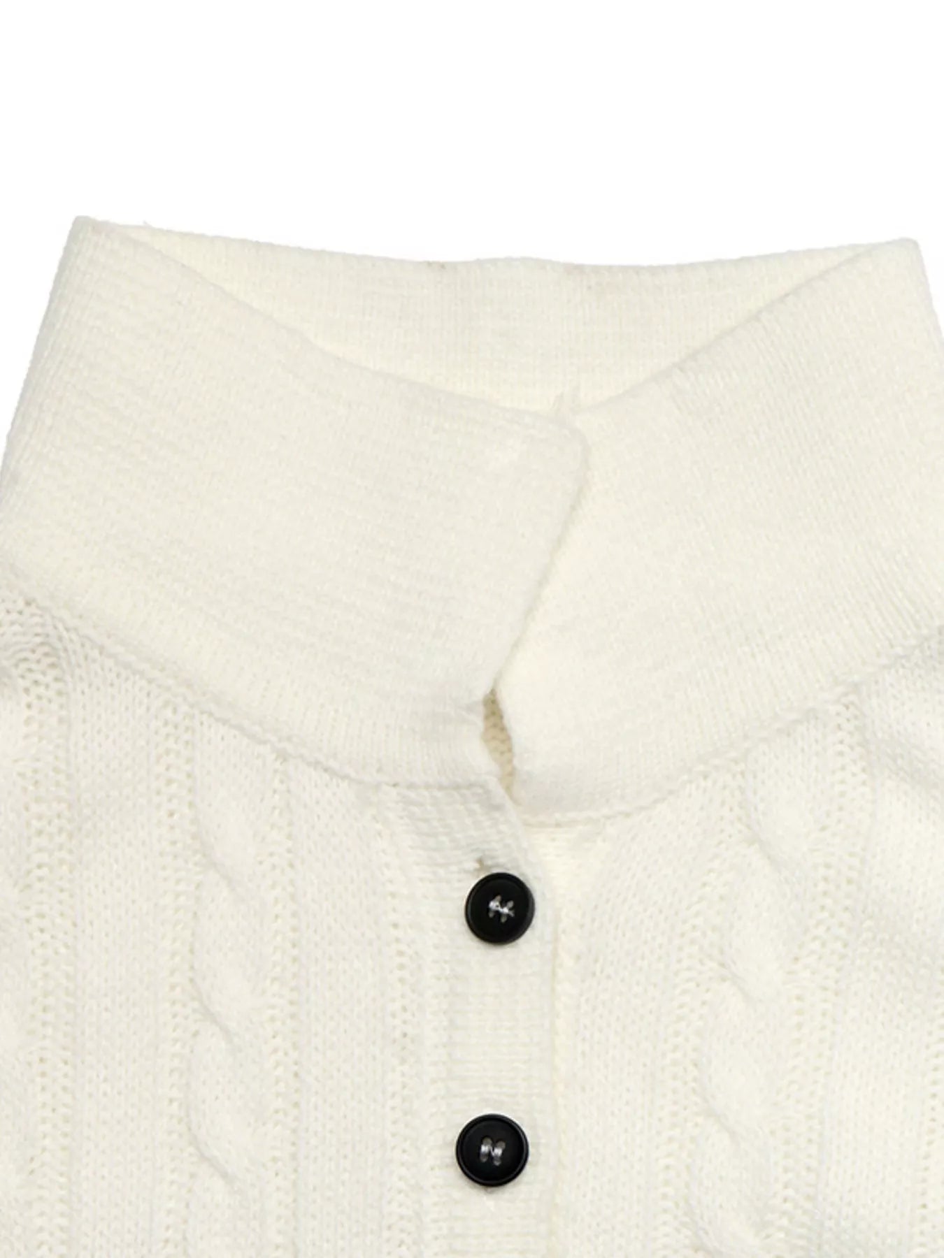 Close up of white cable knit sweater collar and black button placket detail