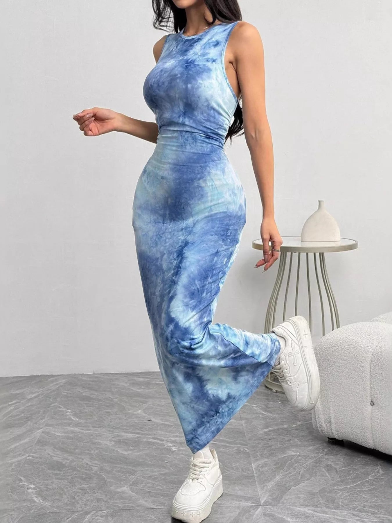 Side view of a sea blue tie dye bodycon maxi dress worn on model, foot raised