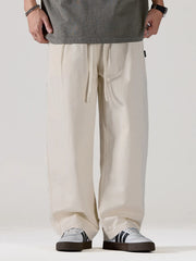 Men's light apricot oversized casual pants with a drawstring waist and pockets.
