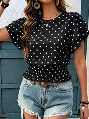 Black polka dot blouse with ruffle sleeves and smocked peplum hem, shown on a model.