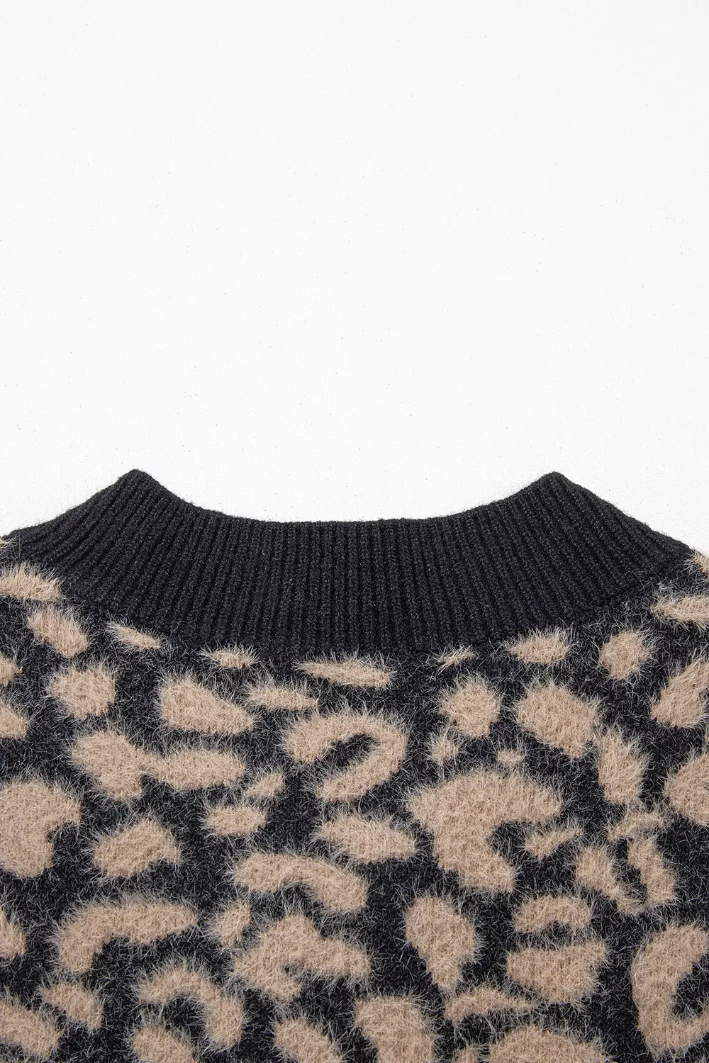 Close up of black ribbed back neckline on leopard print knit vest.