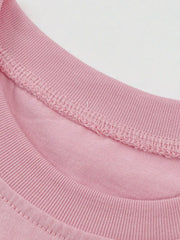 Close up of the pink ribbed round neckline and stitching on the children's T-shirt
