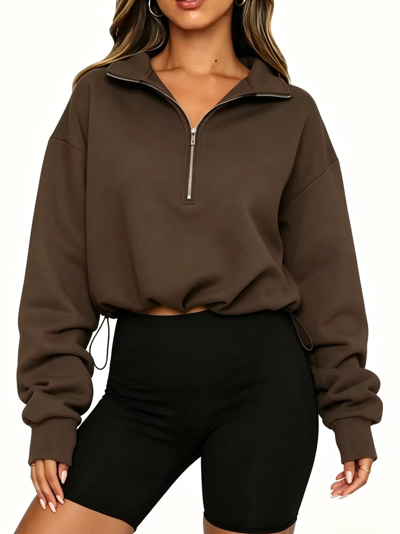 Front view of brown half zip sweatshirt with arms relaxed and drawstring hem