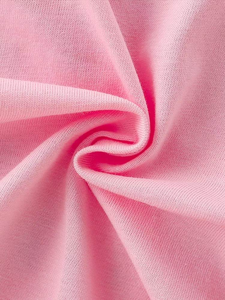 Detail view of soft folded blush pink fabric showing the smooth texture of a children's t-shirt