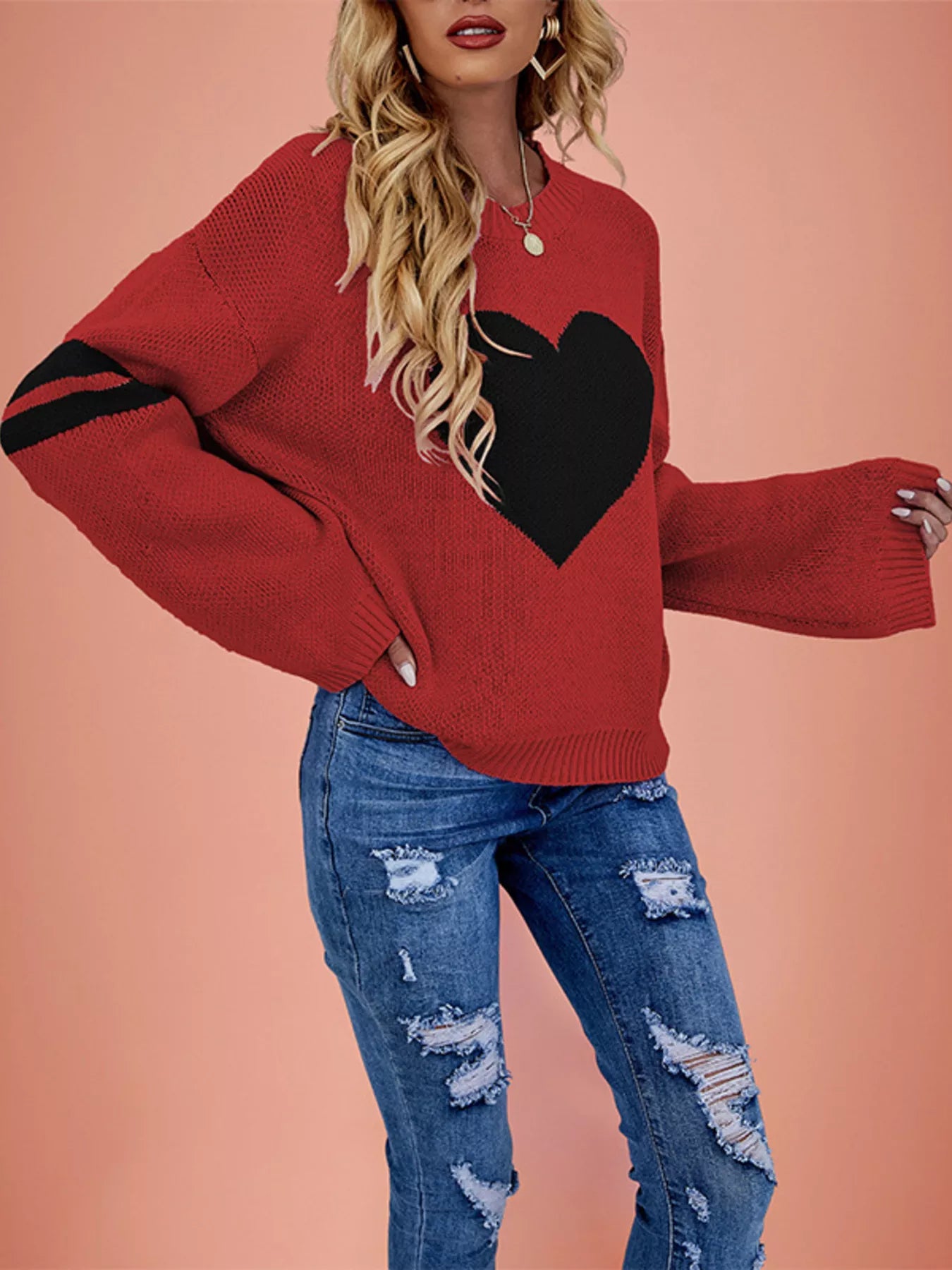 Side view of a red dropped shoulder sweater with a large black heart