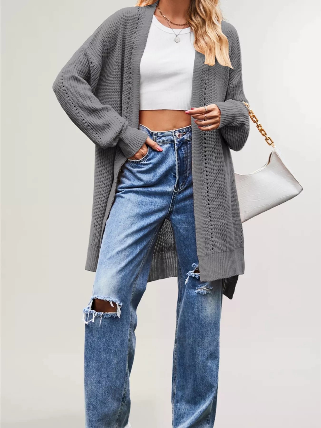 Gray long open front cardigan with openwork stripes worn over jeans