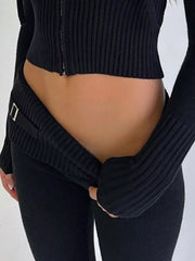 Close up detail of black ribbed cardigan zipper and folded knit pants waistband