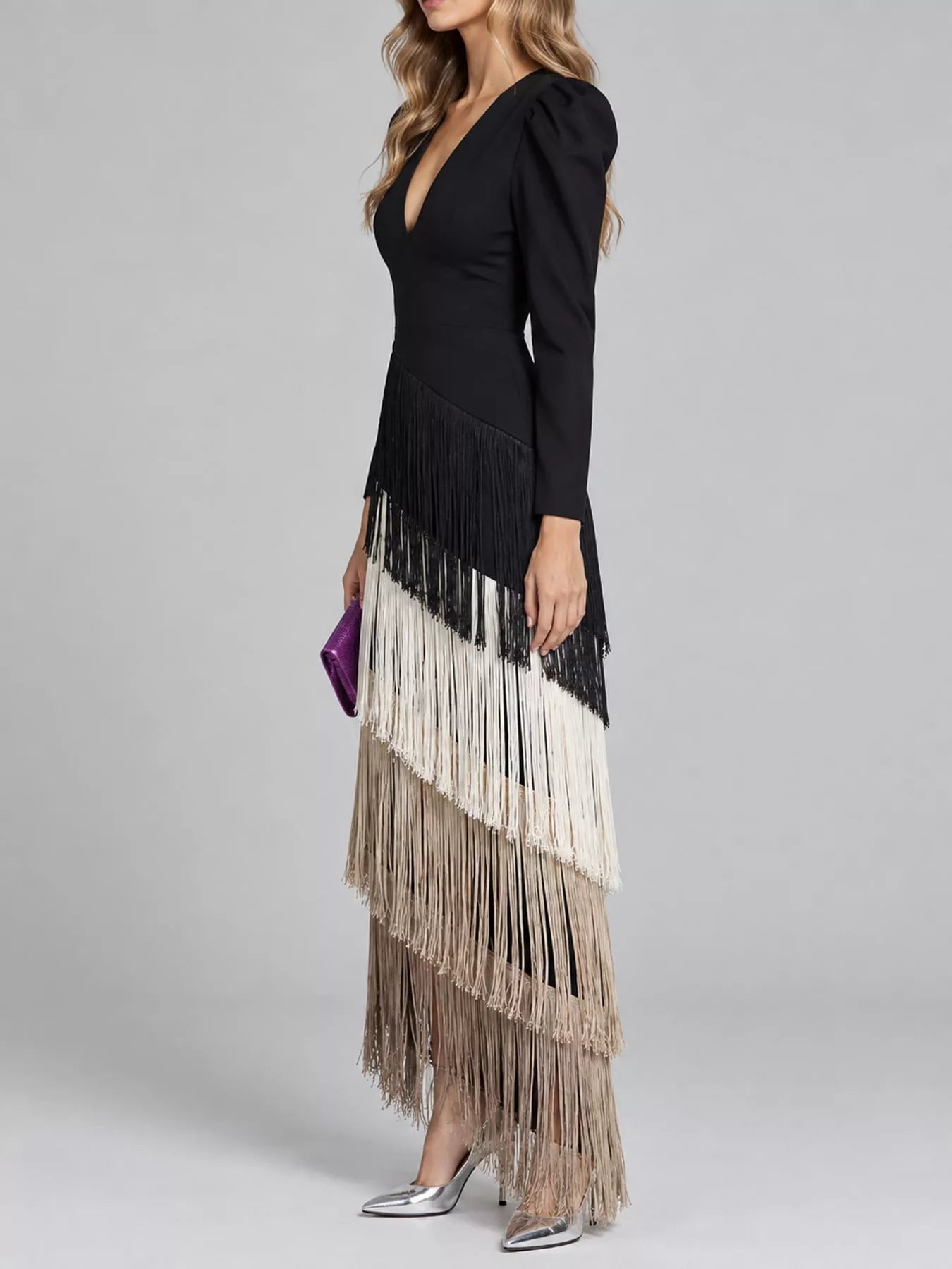 Studio side view of a black fringed maxi dress with cream and taupe fringe tiers
