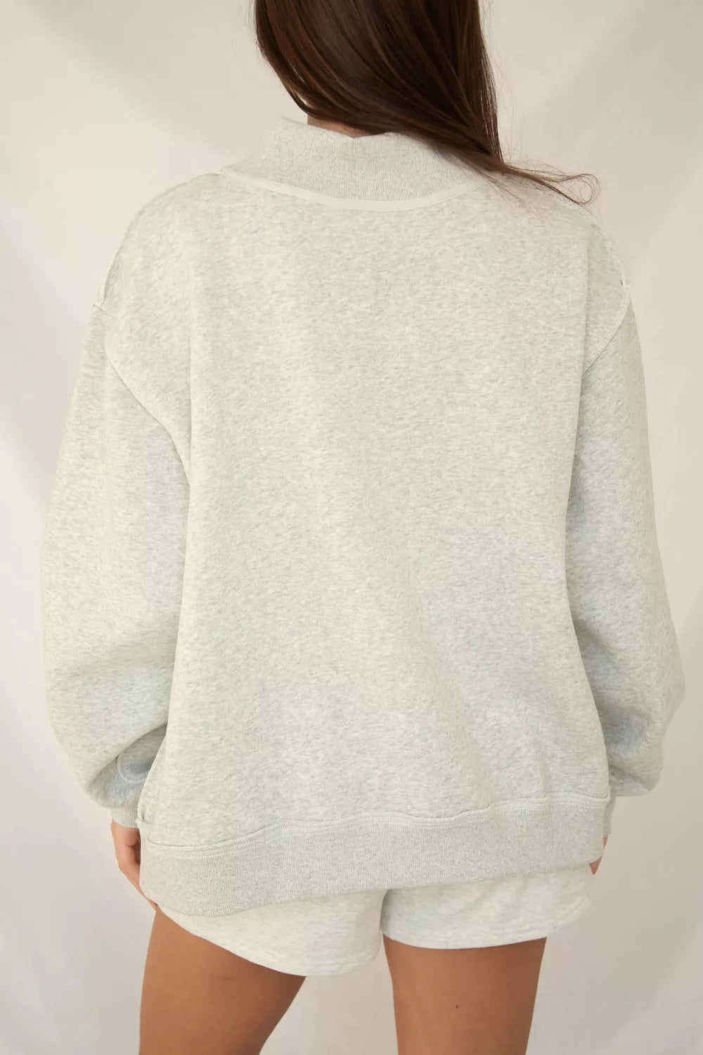 Back view of plain beige crew neck sweatshirt with ribbed cuffs and hem