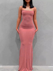 Front view of a burnt coral spaghetti strap bodycon maxi dress against a plain gray wall