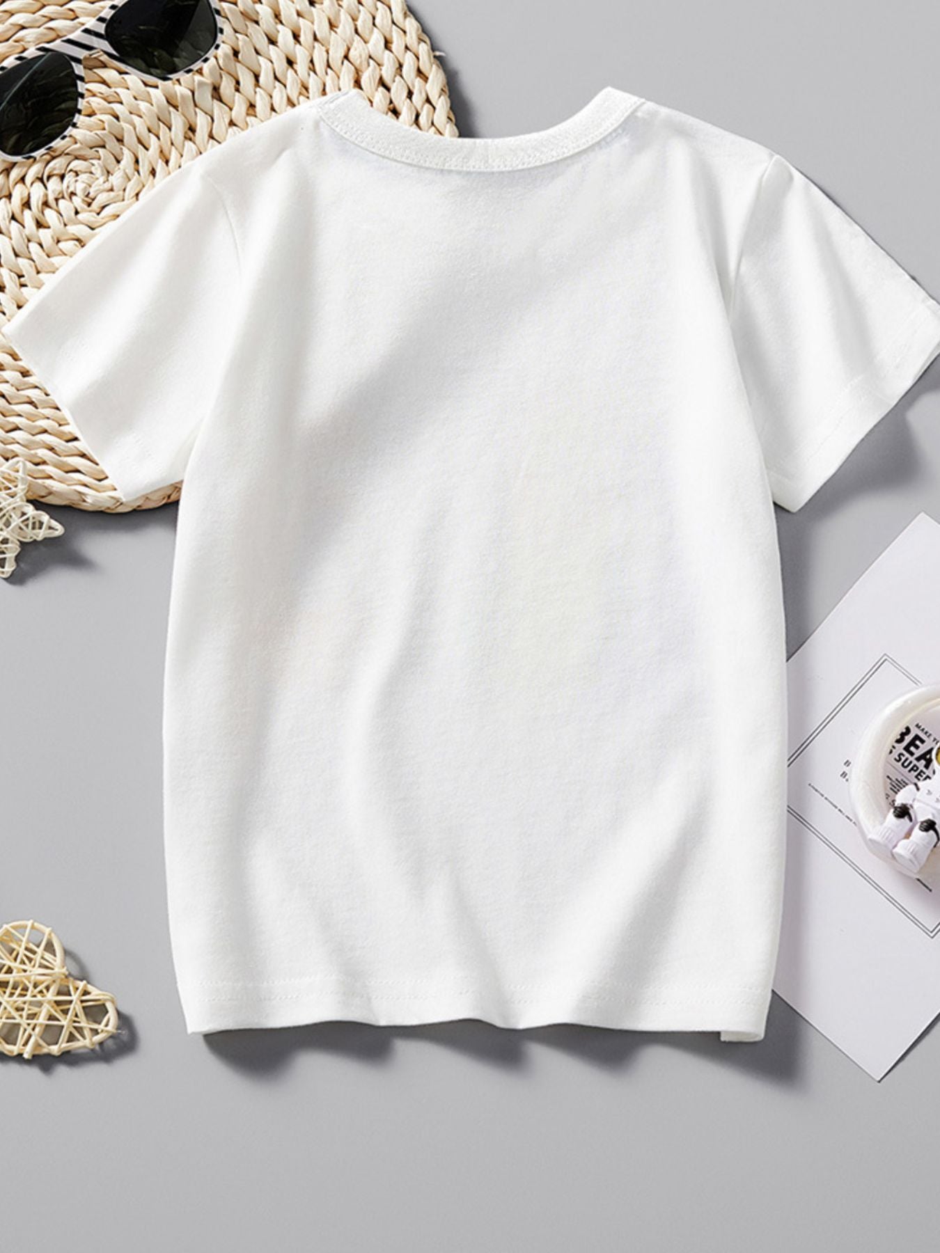 Back view of plain white children's T-shirt with short sleeves laid flat