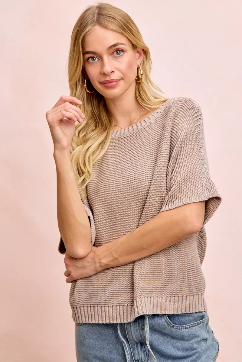 Front view of washed mocha dolman knit top with arms crossed in front.