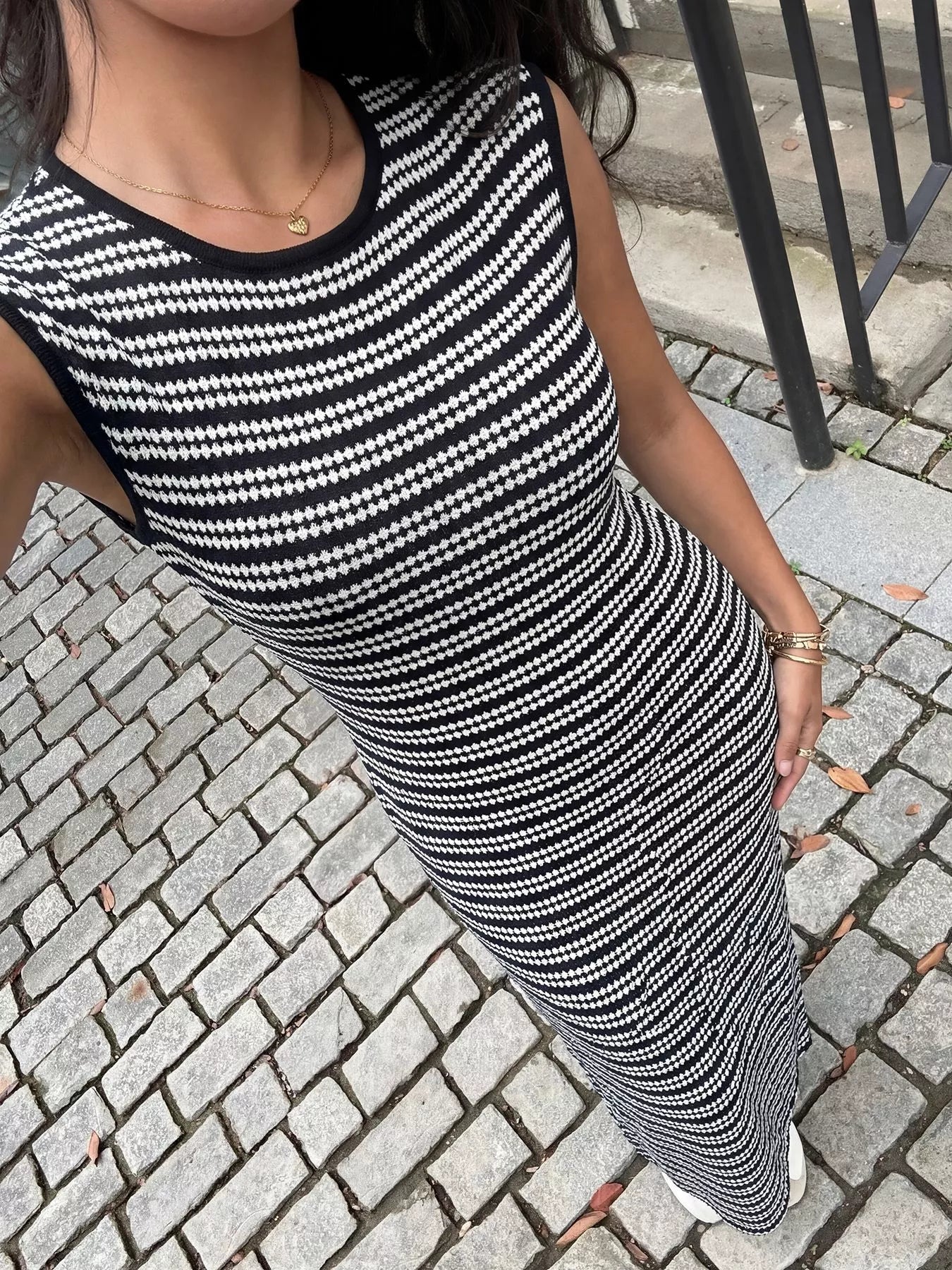 High angle view of a black and white striped sleeveless knit maxi dress showing the knit texture