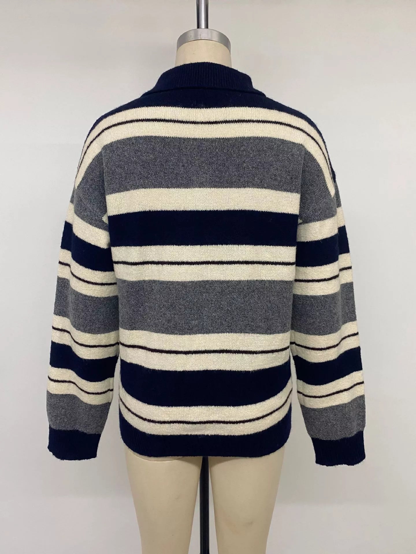 Back view of the striped polo sweater displayed on a mannequin
