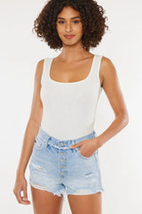 Women's distressed denim shorts with a button fly, raw hems, and pockets.