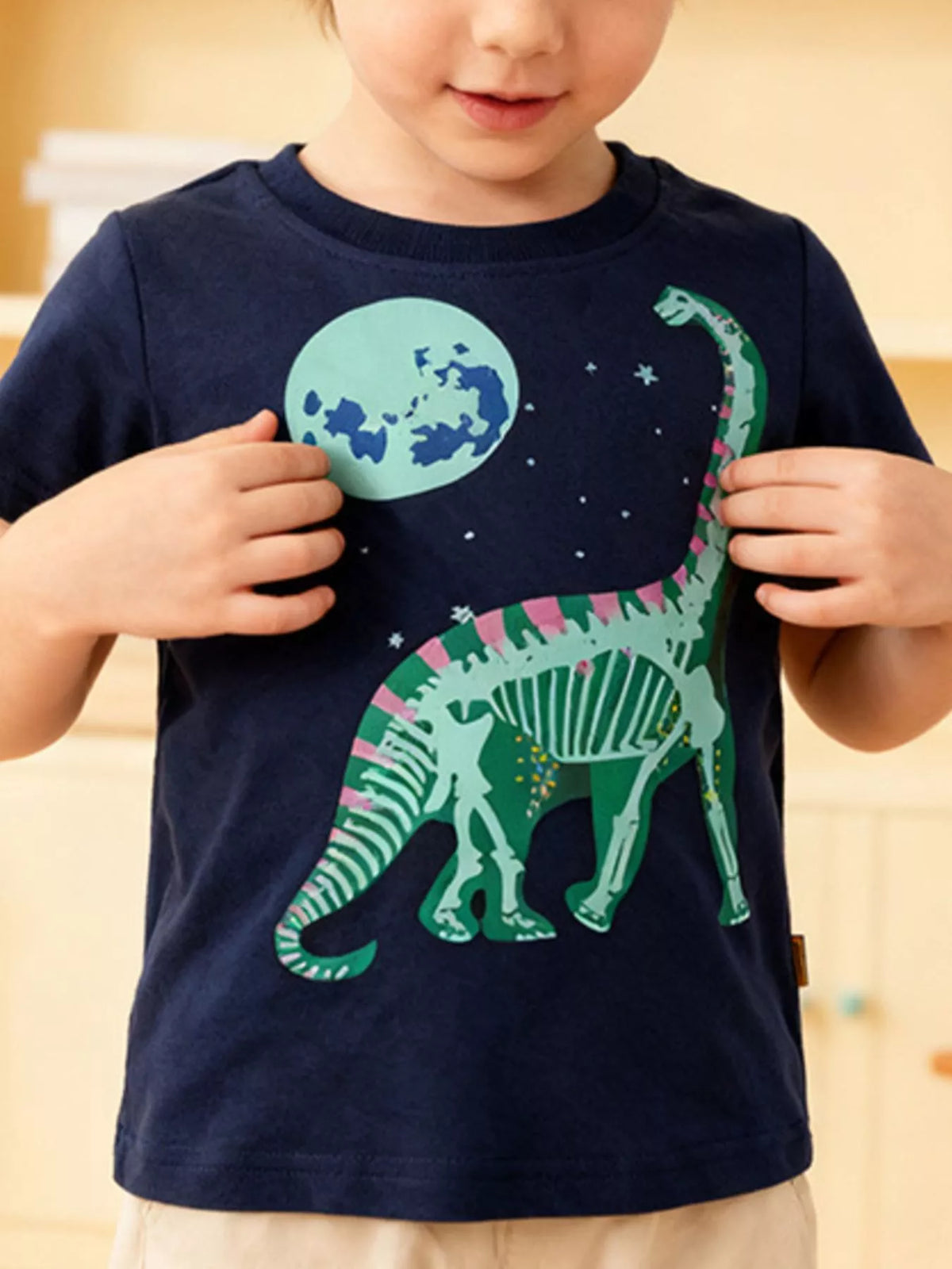 Children's navy blue crew-neck T-shirt featuring a dinosaur graphic.