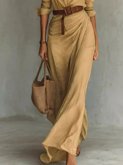 Lower view of a camel shirt maxi dress showing the draped skirt and brown belt detail