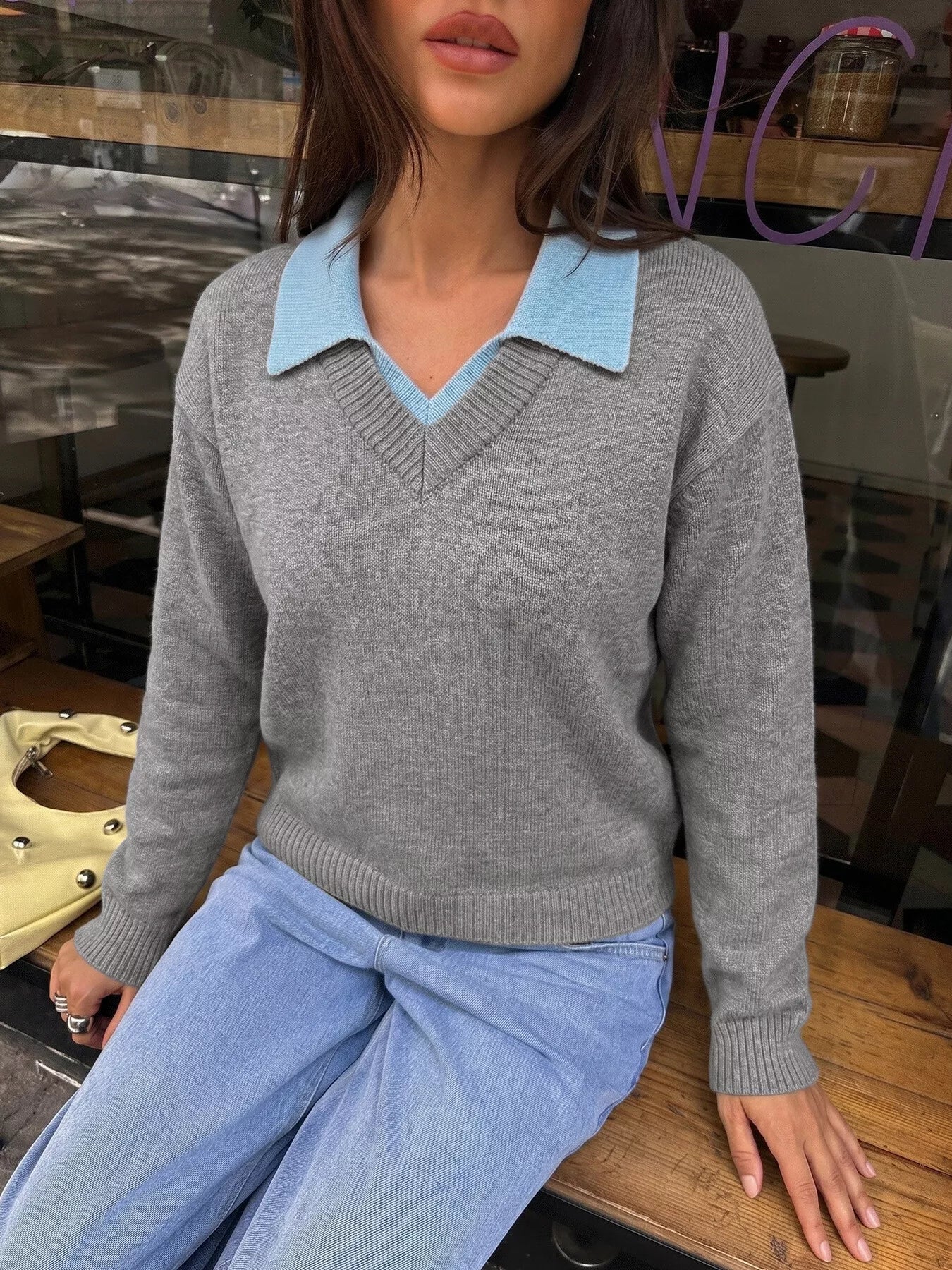Seated front view of the gray knit sweater with a light blue polo collar