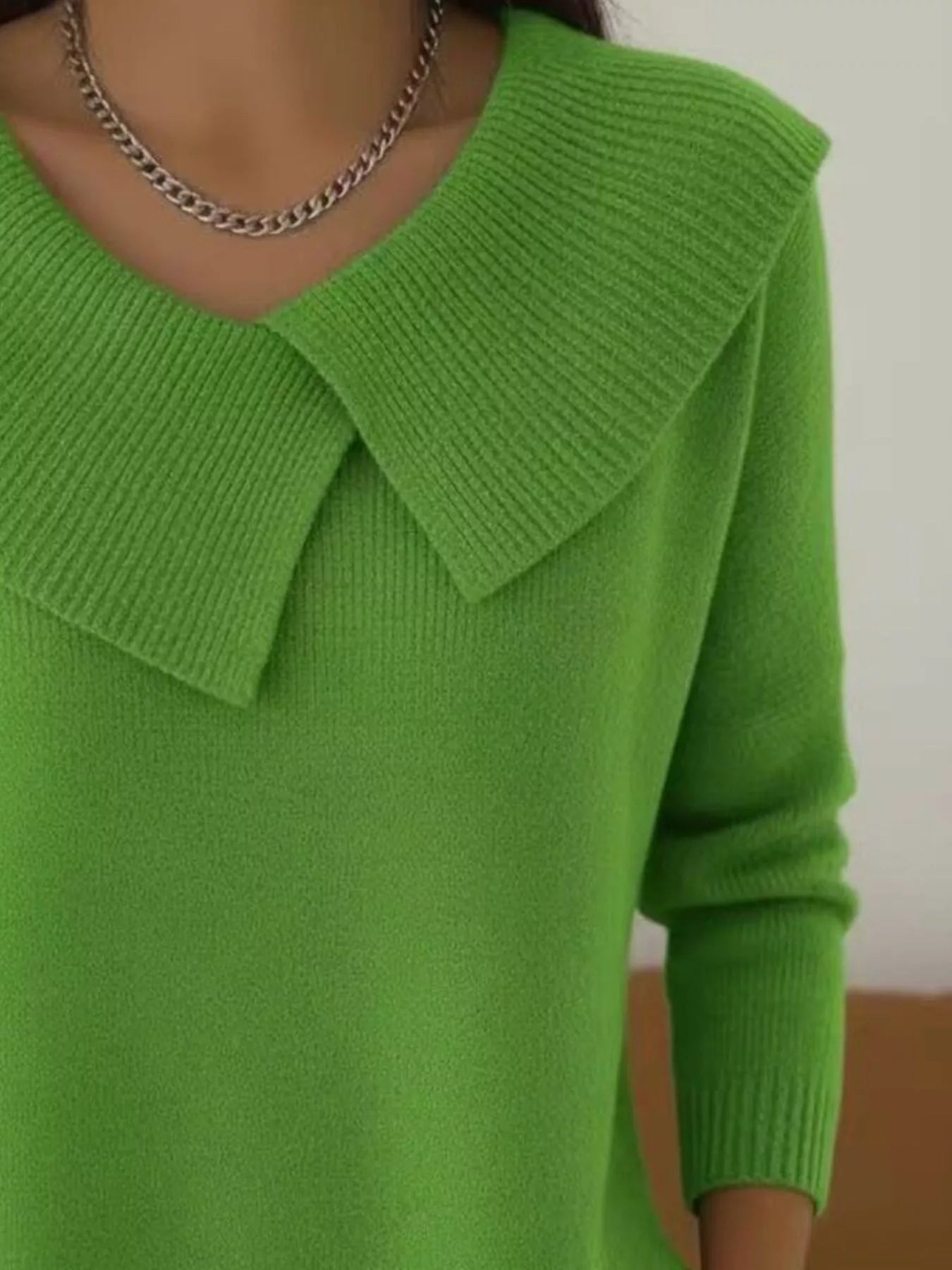 Close up of bright green wide collar ribbed knit sweater showing overlapping collar and ribbing