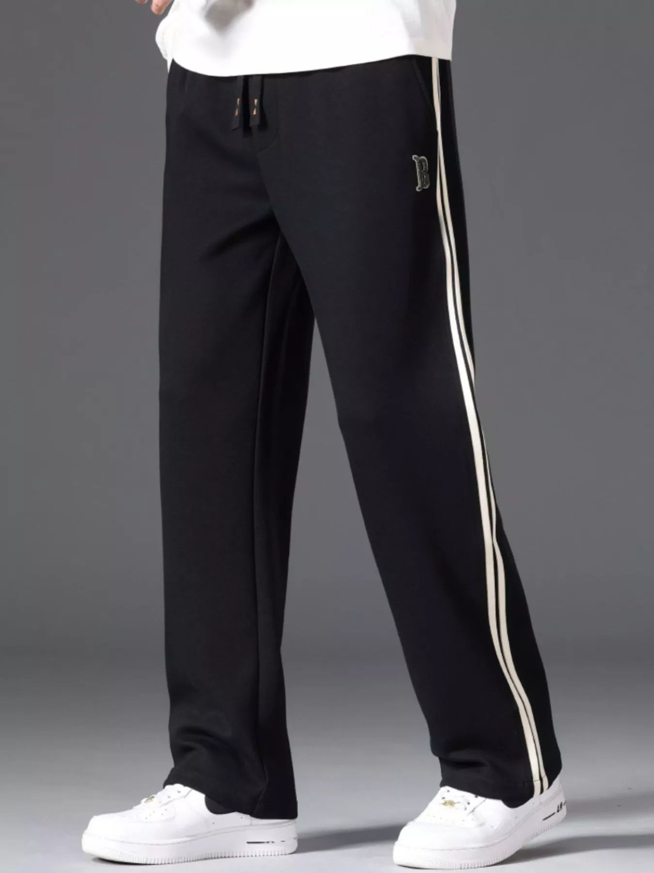 Men's side striped casual pants with a drawstring waist and pockets.