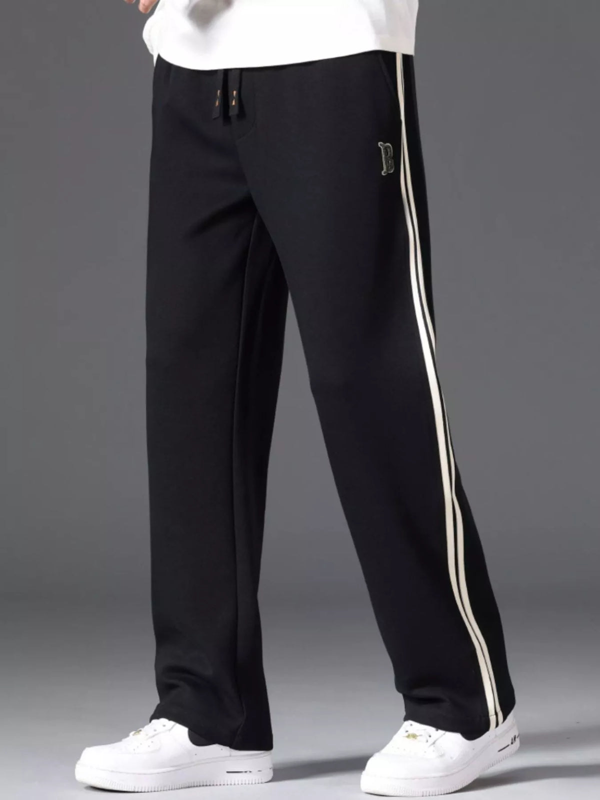 Men's side striped casual pants with a drawstring waist and pockets.