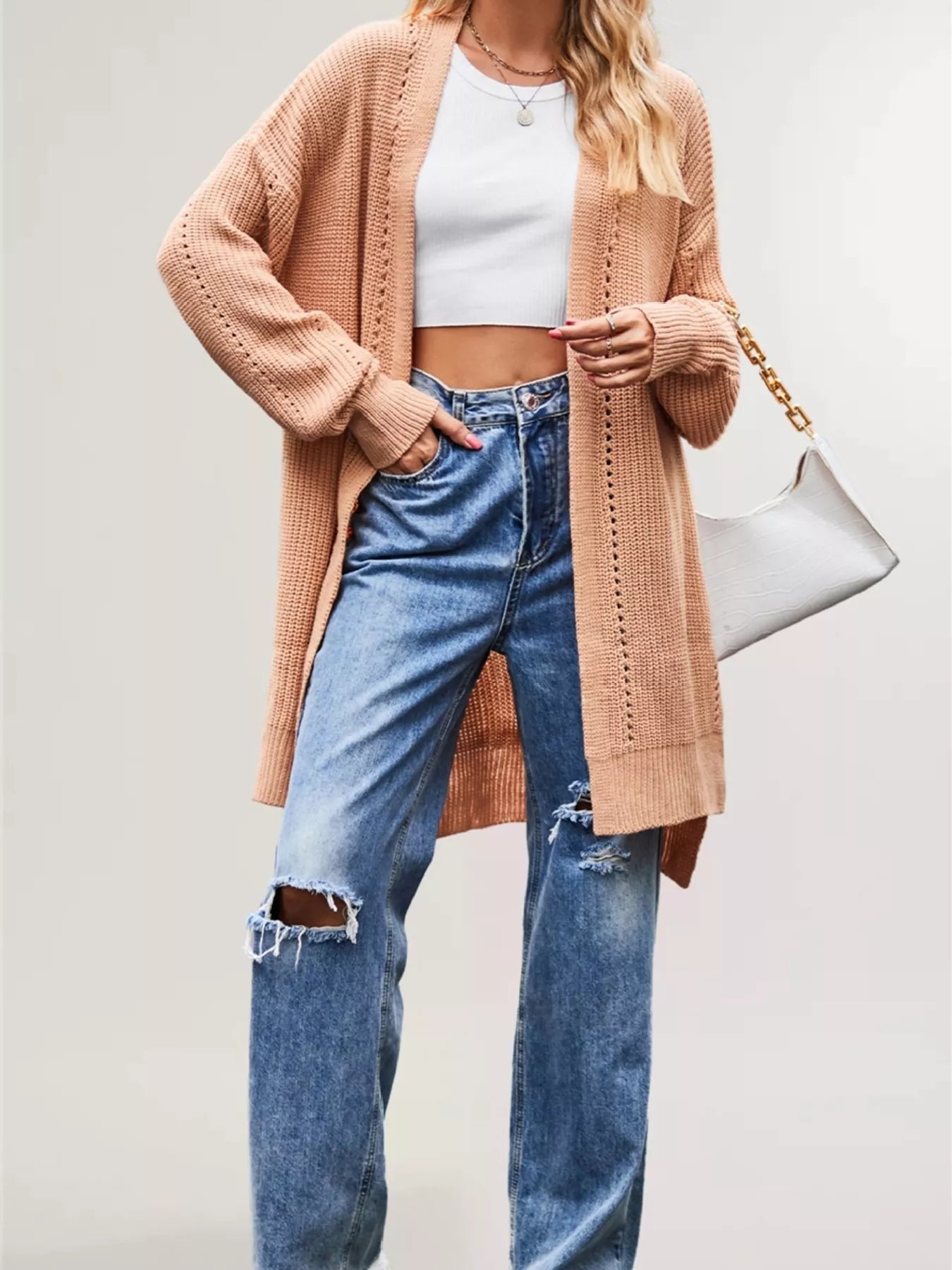 Apricot long open front cardigan with openwork stripes worn over jeans