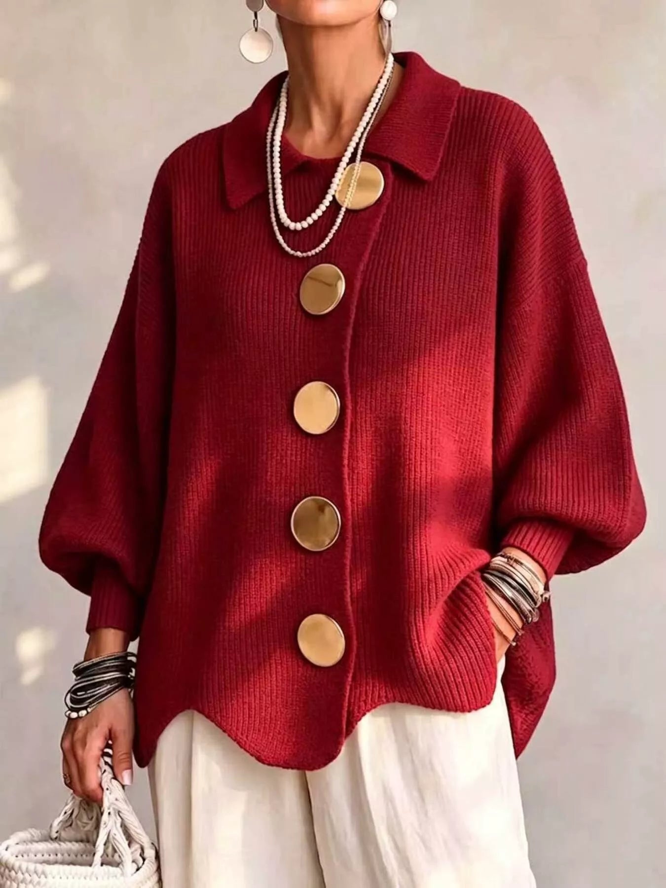 Front view of a deep red knit cardigan with large gold buttons