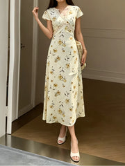 Front view of a yellow floral midi dress with crossover lace trim at the waist