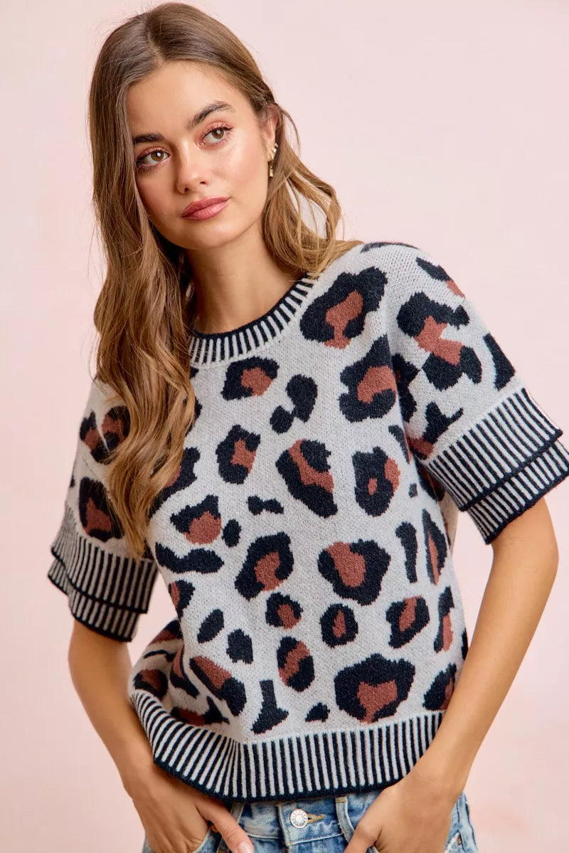 Front view of a light gray leopard print knit top with striped trim.