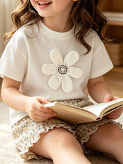 White children's t-shirt with large padded flower applique, shown worn in a front view