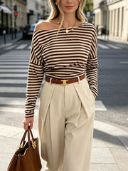 Front view of coffee brown and cream striped one shoulder long sleeve top worn on model outdoors