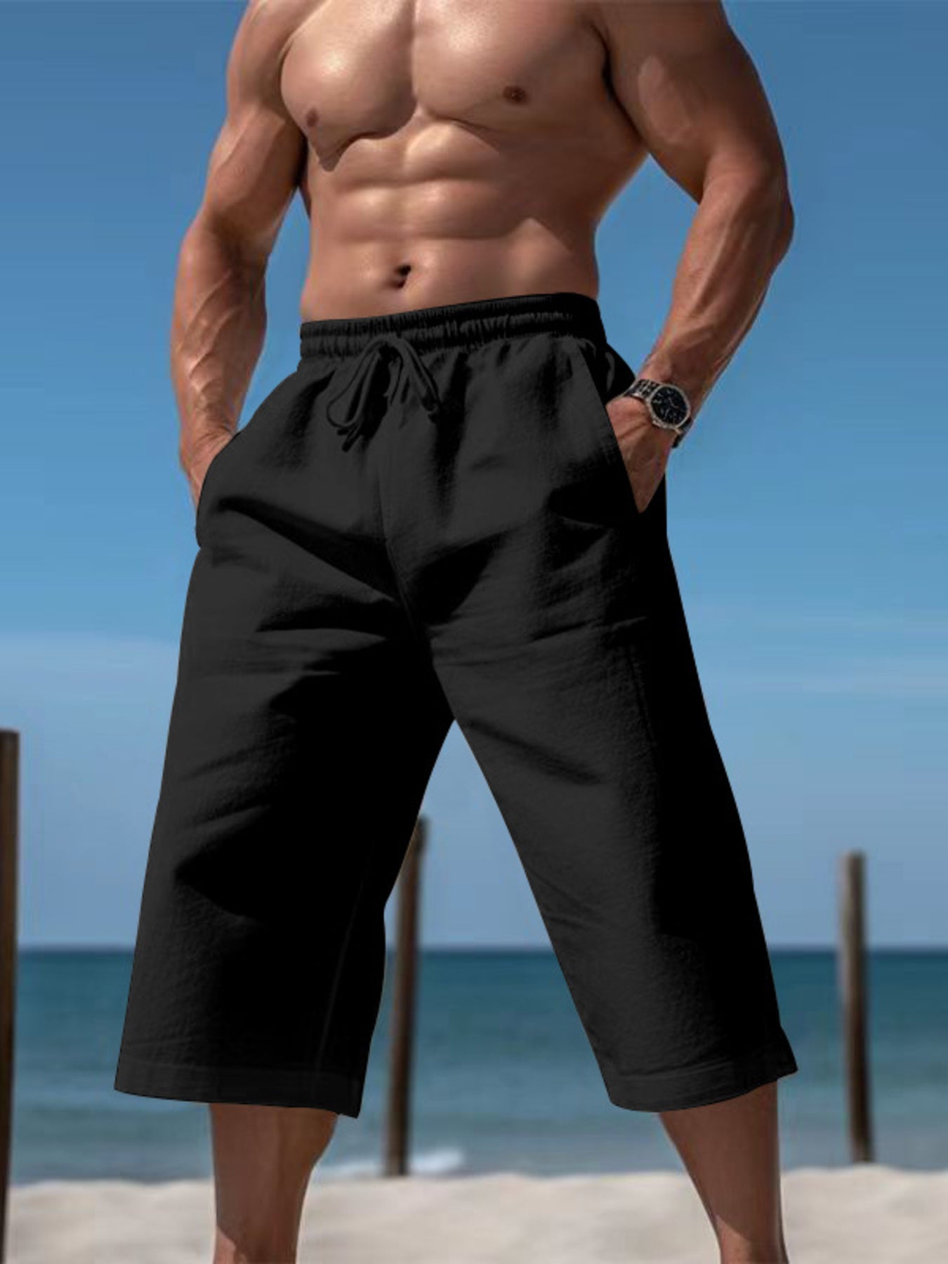 Men's black cropped casual pants with a drawstring waist and pockets.