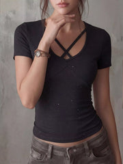 Black fitted short-sleeve T-shirt with crisscross neckline straps and subtle white speckled pattern, shown on model.