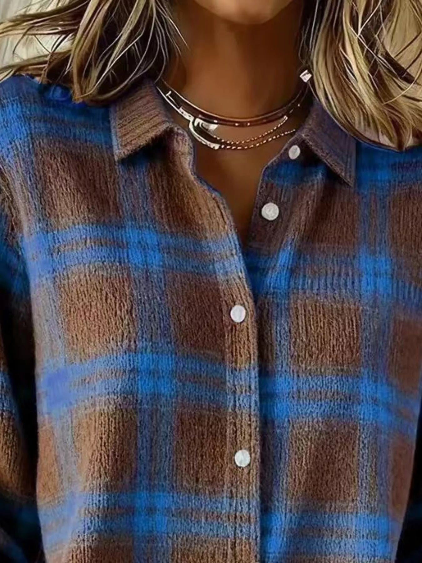Close-up of the collar and button placket on a brown and blue plaid knit cardigan