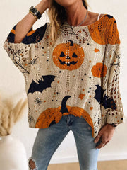 Front view of a beige openwork knit cover up with orange jack o lanterns, bats, and spider webs.