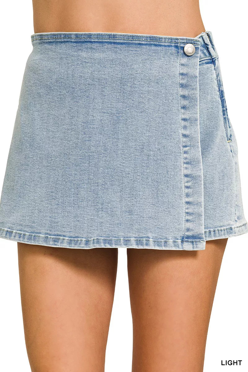 Women's light-wash denim skort with a wrap front and asymmetrical hemline.