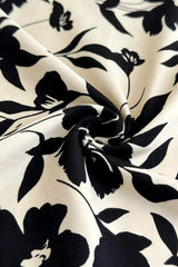 Close detail view of khaki floral fabric with large black flowers and leaves
